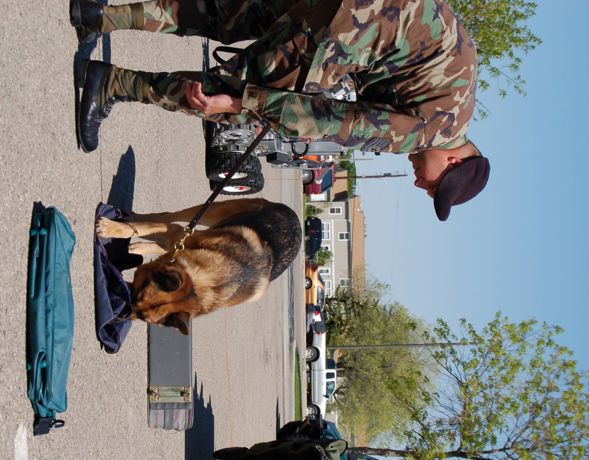 Tech. Sgt. Michael Laughlin, 319th Security Forces Squadron, directs his dog Indy to sniff luggage for explosives during the military working dog demonstration for Police Week May 16. (U.S. Air Force photo/ Airman 1st Class Ashley Coomes)