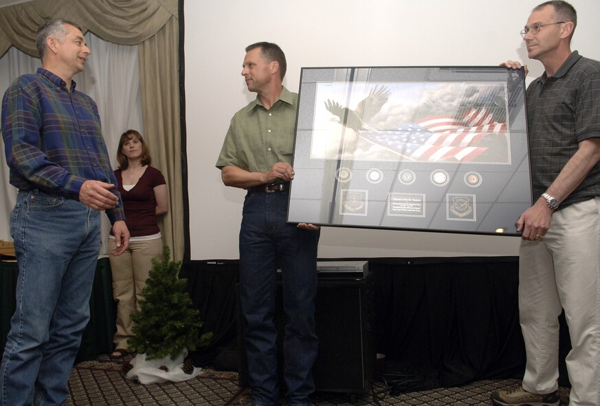 FAIRCHILD AIR FORCE BASE, Wash. -- Col. Roger Watkins, 92nd Air Refueling Wing vice commander, and Col. Mark Melville, 92nd Operations Group commander, present Col. Scott Hanson, 92nd ARW commander, with a framed photo as farewell gift from all of the colonels. (U.S. Air Force photo/ Senior Airman Chad Watkins)