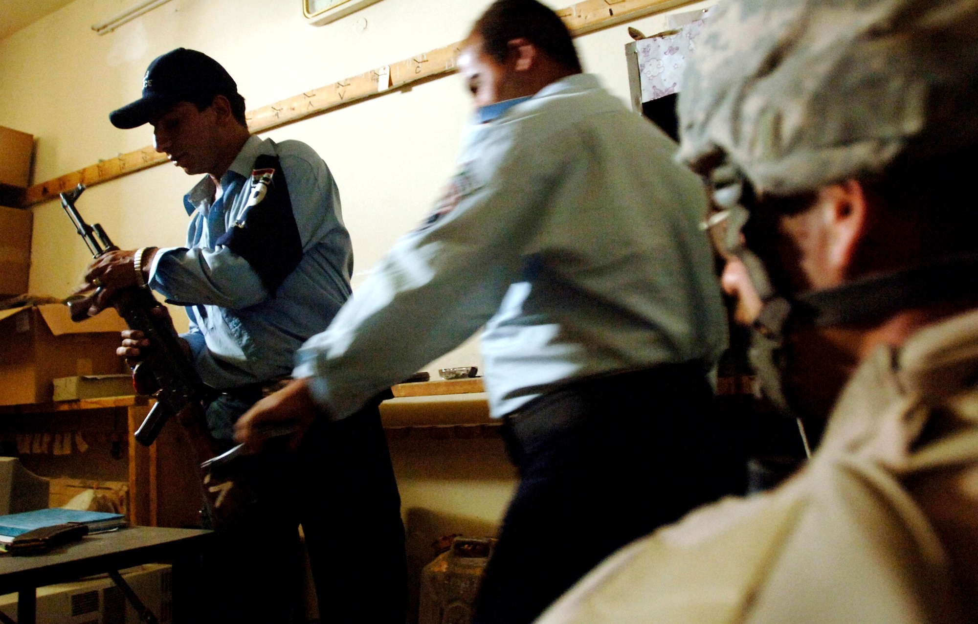 Iraqi police return weapons during a mentoring session with Staff Sgt. Michael Ellis May 9 in a Baghdad police station. Members of Det. 3, 732nd Expeditionary Security Forces Squadron, perform police transition team duties of mentoring, coaching and teaching Iraqi police. (U.S. Air Force photo/Tech. Sgt. Cecilio M. Ricardo Jr.) 
