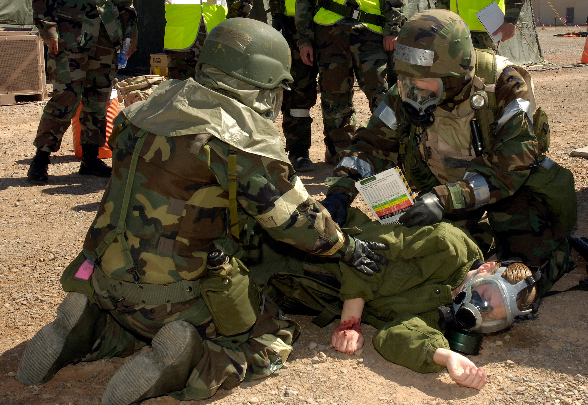 Airmen perform self aid and buddy care in full mission oriented protective posture gear after a simulated chemical attack as part of a deployment exercise at Holloman Air Force Base, N.M., May 7. (U.S. Air Force photo/Airman 1st Class Michael Means) 