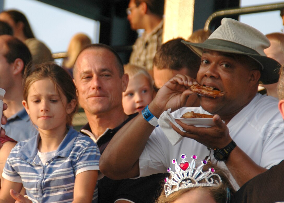 Chief Master Sgt. Ben Futrell, 315th Airlift Wing command chief master sgt., Charleston AFB, S.C. (left), and Master Sgt. Kervin Wilson, first sergeant with the 317th Airlift Squadron (right), enjoys the River Dog's baseball game during their annual military appreciation night.  (Photo by Capt. Wayne Capps, USAFR)