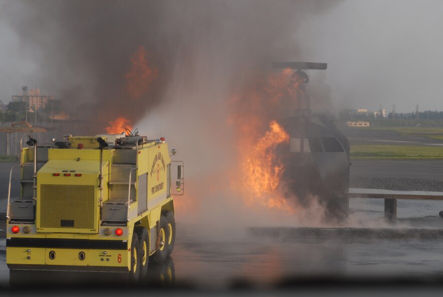 The 374th Civil Engineering Squadron Fire Department puts out a fire during a simulated plane crash as part of Beverly Morning 07-05. Beverly Morning is an exercise that tests and trains Airmen in war time scenarios.(U.S. Air Force photo by Airman 1st Class John M. Albea VIRIN 070508-F-5223A)