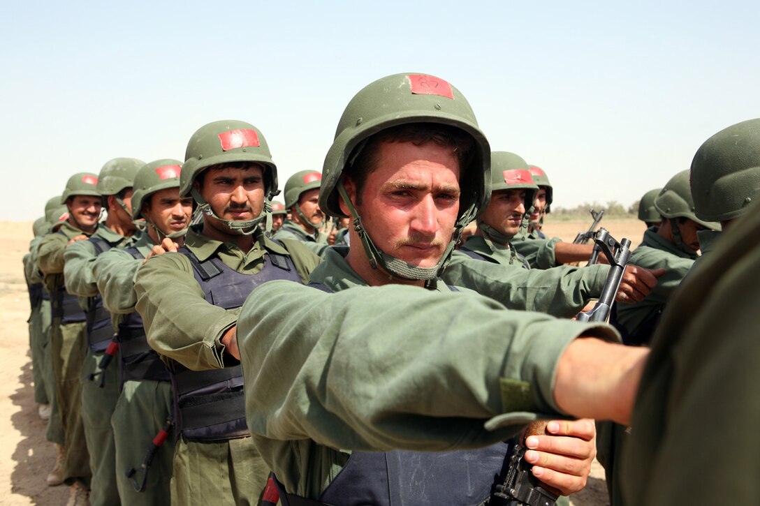 Provincial Security Force recruits jostle for alignment while in formation during training at Camp Baharia, Iraq, May 19. This PSF, composed largely of volunteers from the Albu Issa tribe, graduated May 23 and left immediately following the graduation ceremony to take the fight to Al Qaeda. A 33-year-old member of the class, who asked that his name not be used, said through a translator, "I volunteered for myself and my family to fight those terrorists. Most Muslims don't accept Al Qaeda's way."