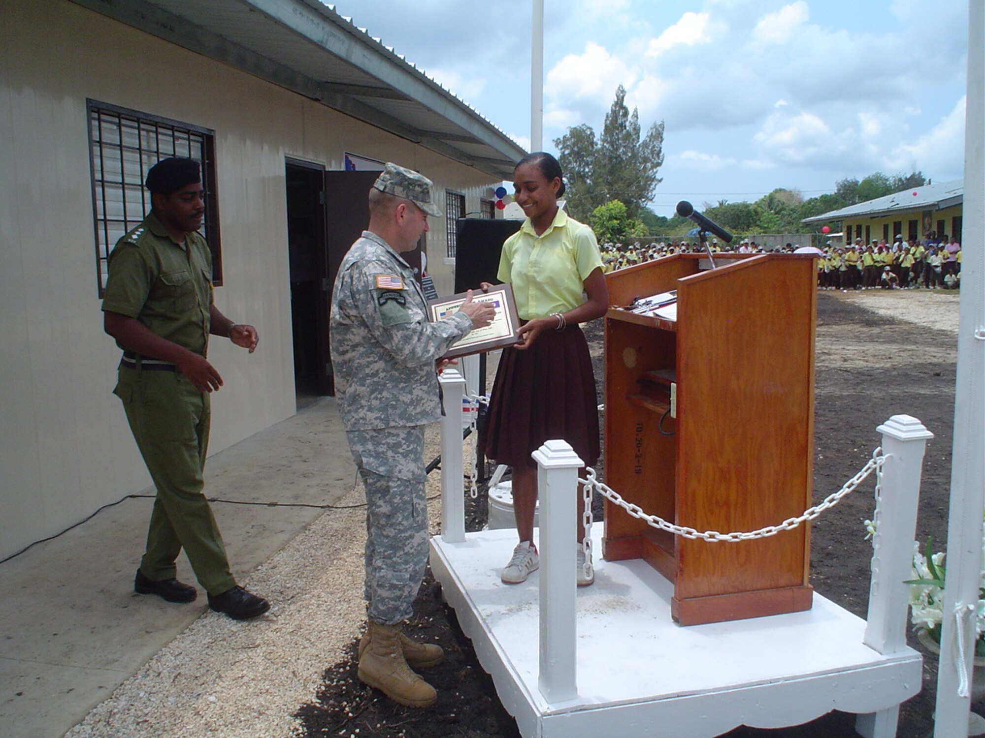 Brig. Gen. Ken Keen receives a thank-you plaque from a girl who will attend the newly constructed school in Hattiesville, Belize, May 18.  This two-room school is one of four schools built by U.S. and Belizean Defense Forces personnel.  U.S. Air Force photo by Capt. Alysia Harvey