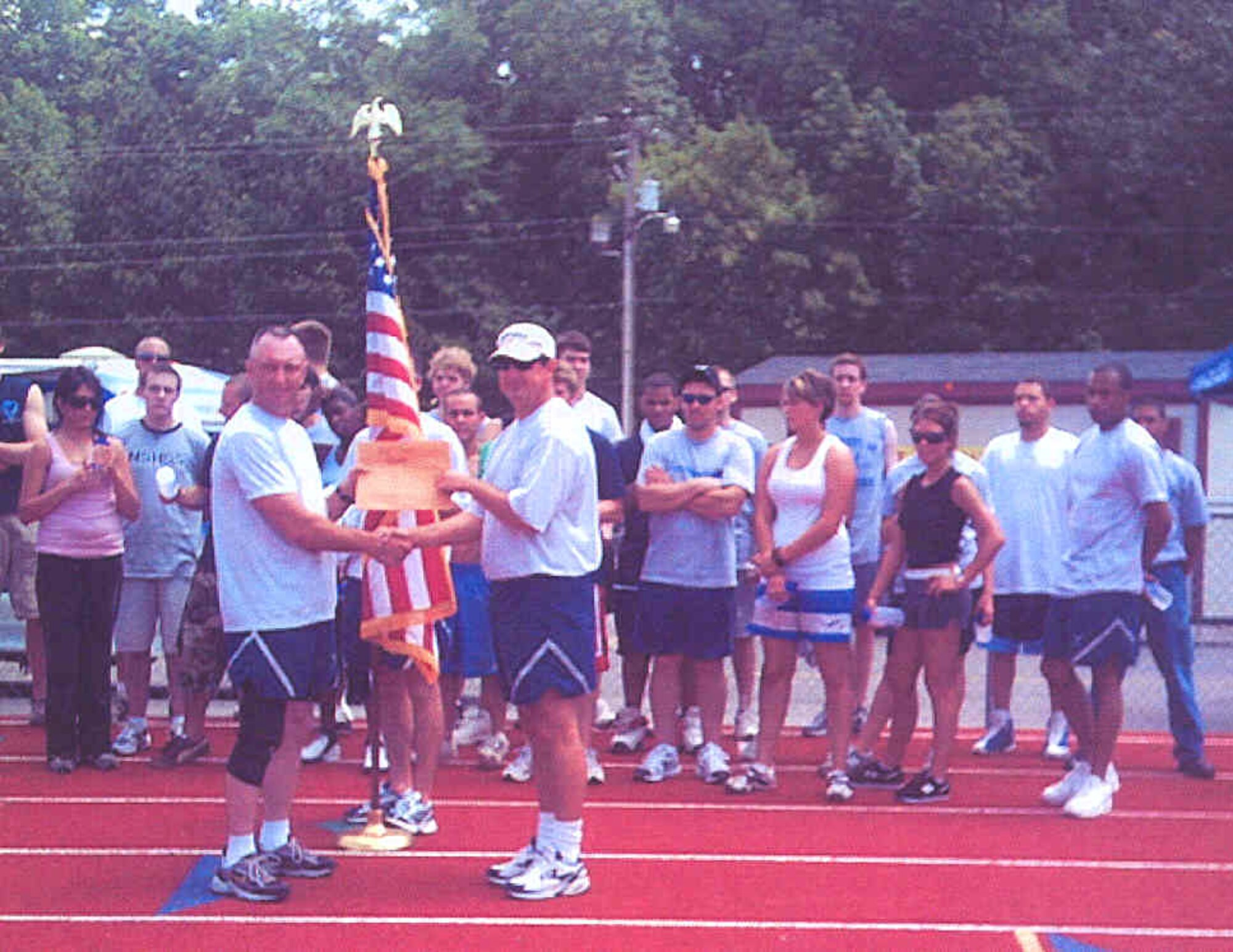 Delayed Entry Program members and Airmen of the 348th Recruiting Squadron, along with Lt. Col. Kenneth Walters, squadron commander, present an $800 check for the American Red Cross relief fund for Dumas, Ark., May 12. The squadron participated in a 25-mile relay run that day at a local high school to raise the relief funds. Many families in the town of Dumas lost their homes and personal belongings to a tornado and wind storms Feb. 25.