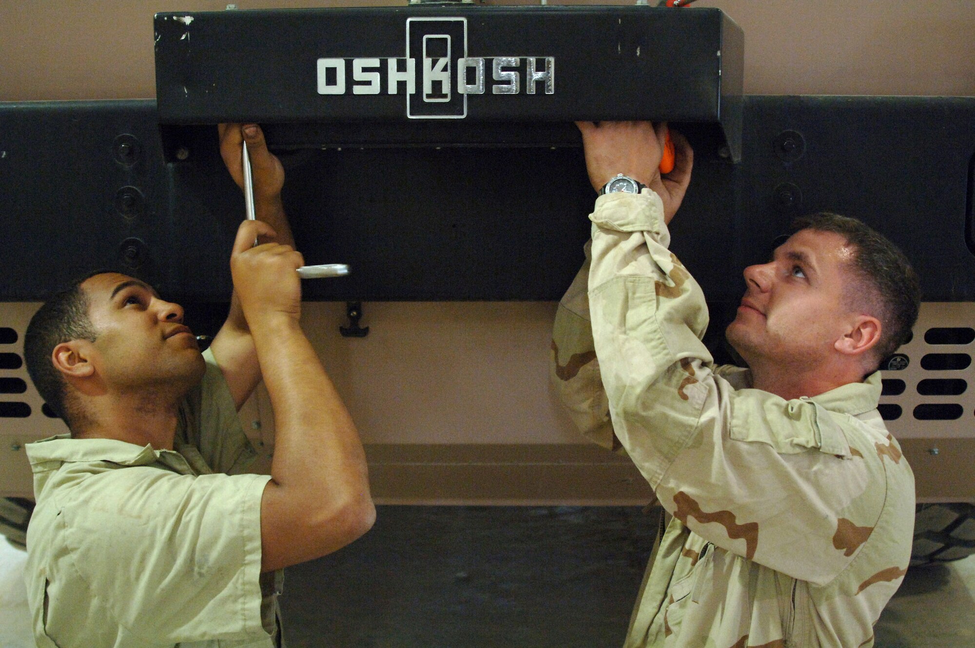 Senior Airmen Joseph Baltes and Jeremy Camper adjust the pneumatic speed control on a crash response truck April 25 at Balad Air Base, Iraq. Both Airmen are special purpose vehicle mechanics with the 332nd Expeditionary Logistics Readiness Squadron. Airman Baltes is deployed from Charleston Air Force Base, S.C., and Airman Camper is from McGuire AFB, N.J. (U.S. Air Force photo/Senior Airman Candace Romano)