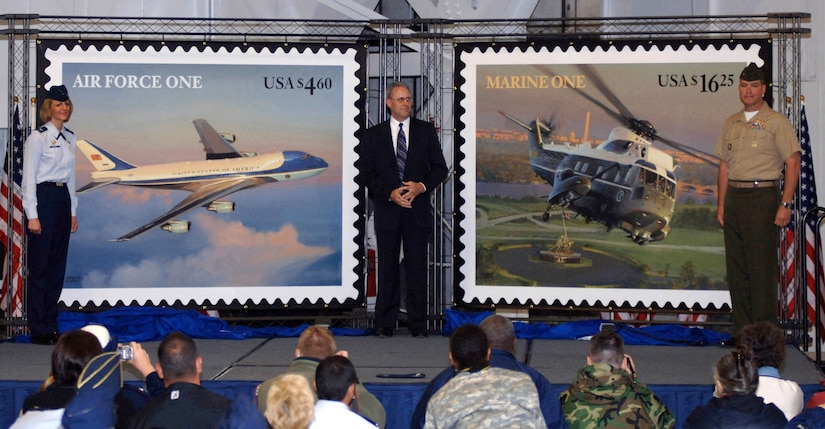David Failor, executive director of Stamp Services for the U.S. Postal Service, stands with Col. Margaret Woodward, 89th Airlift Wing commander, and Col. Andrew O'Donnell Jr., commanding officer, Marine Helicopter Squadron One, after unveiling new U.S. Air Force and U.S. Marine postal stamps during the Joint Service Open House at Andrews Air Force Base, Md. The stamps will be available June 13 at all post offices across the U.S. (U.S. Air Force photo/Tech. Sgt. Jason W. Edwards)
