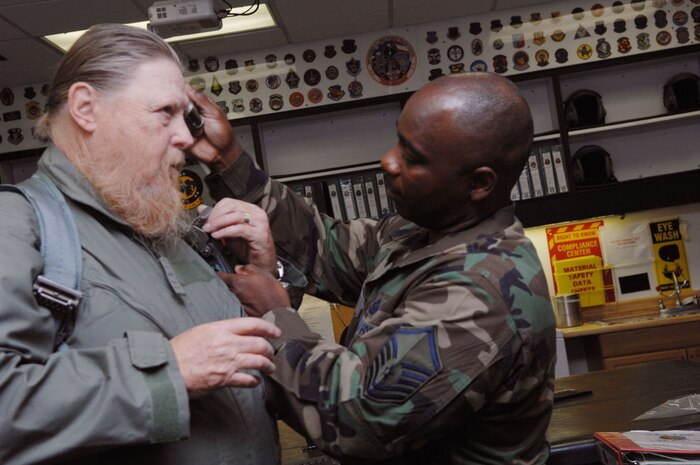 Master Sgt. Keith Mitchell, superintendent of Aircrew Life Support, 422nd Test and Evaluation Squadron, assists Mickey Jones, musician and actor, with his flight suit for an F-16 incentive ride May 17, 2007 at Nellis AFB, Nev. Jones had a recurring role on the hit television show Home Improvement.   (Air Force photo by Tech Sgt. Pamela D. Smith) 