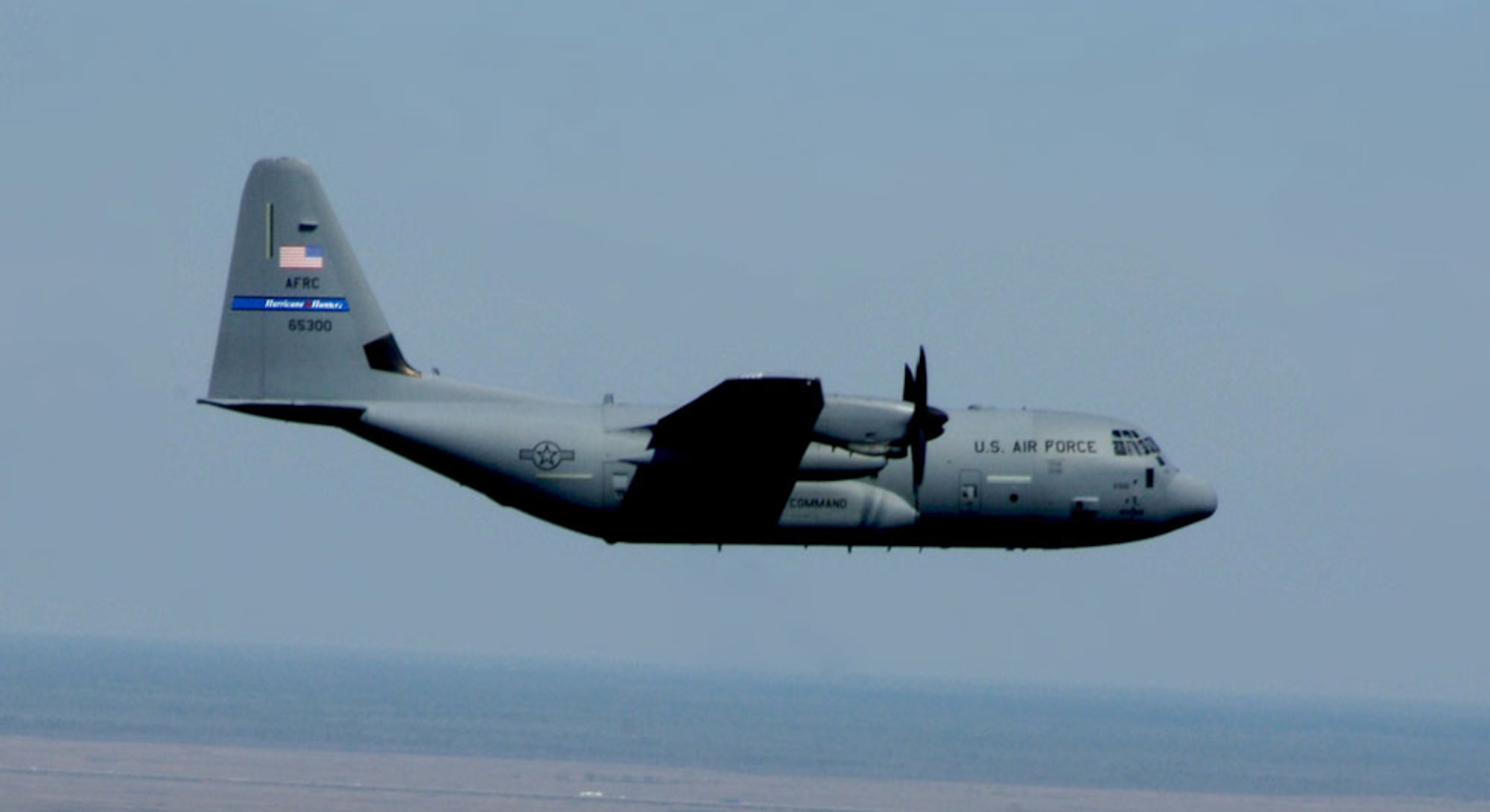 WC-130J "Hurricane Hunter" Aircraft flies over coastline