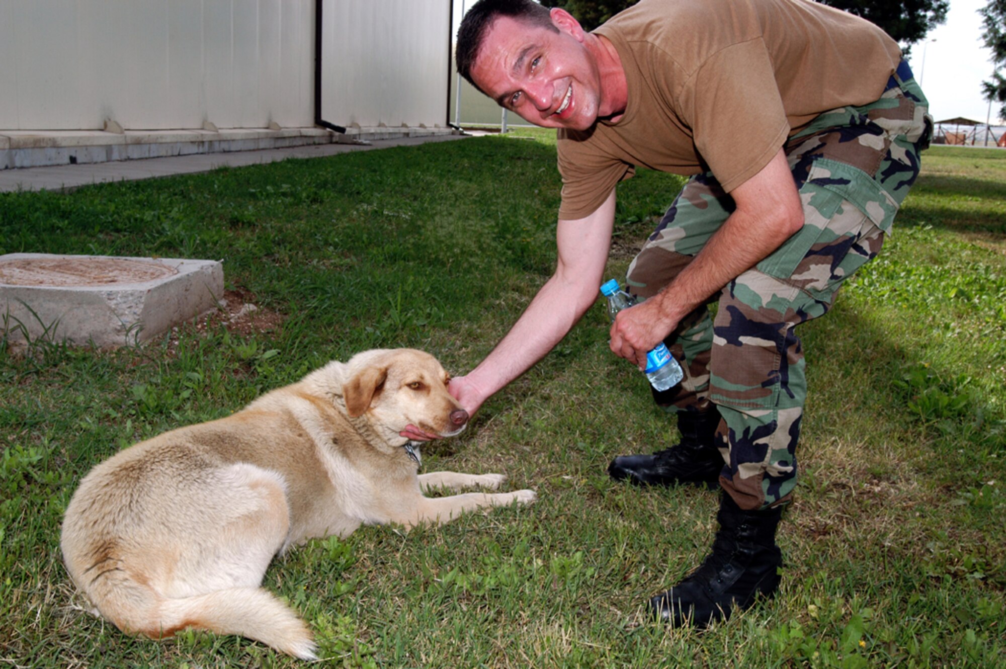 INCIRLIK AIR BASE, TURKEY -- Senior Master Sgt. Chuck Hoover, 434th Aircraft Maintenance Squadron flight chief, reaches down to pet KC.  KC is a Anatolian Shepherd and has been the mascot of the KC-135 Stratotankers and the people that fly and support them at the base since 2003. (U.S. Air Force photo/Senior Airman Mark R. W. Orders-Woempner)
