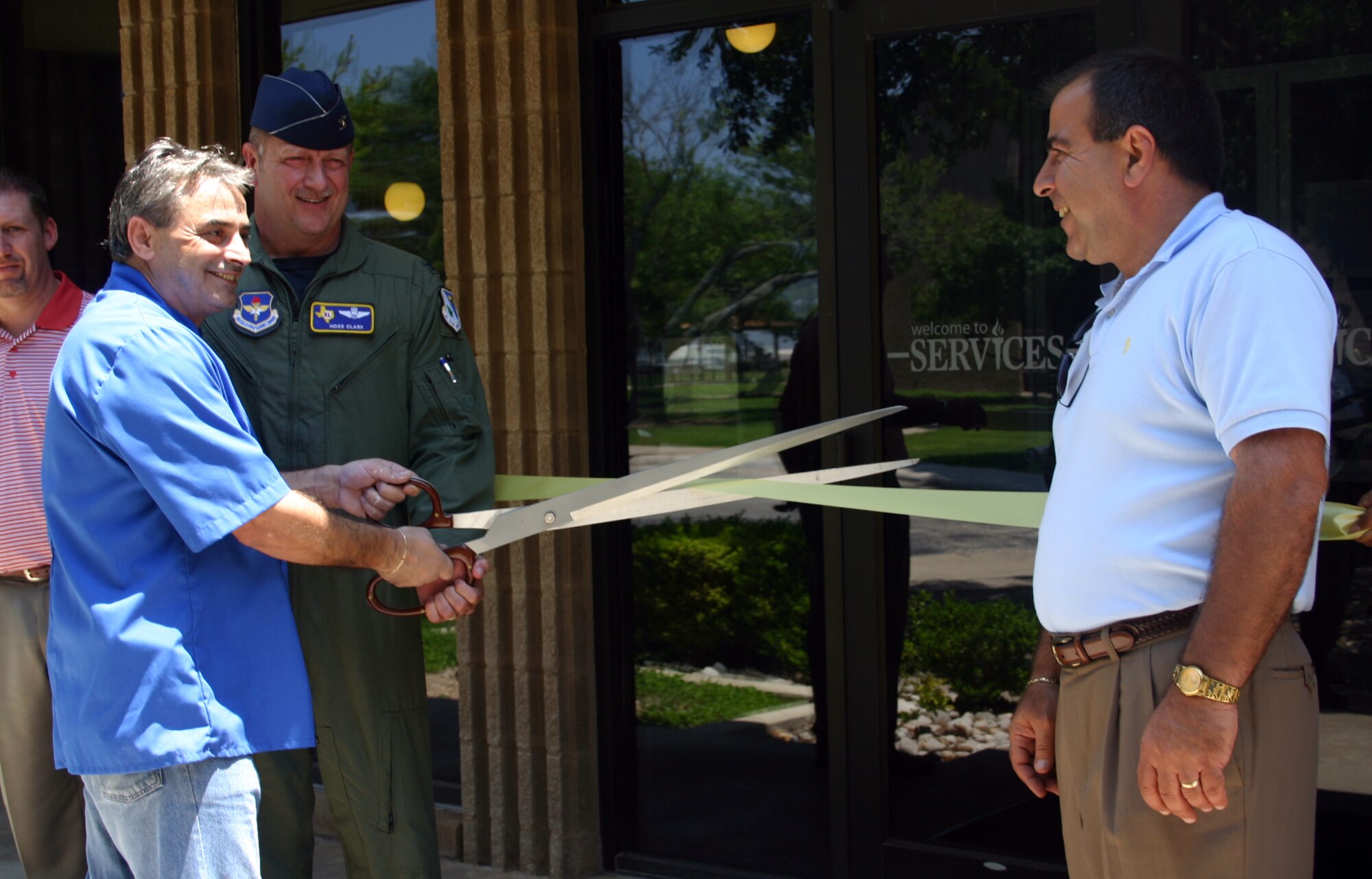 LAUGHLIN AIR FORCE BASE, Texas -- With help from Col. Dan Laro Clark, 47th Flying Training Wing vice commander, George Costas, owner of Zorba's Greek and Italian Restaurant, cuts the ceremonial ribbon at the eating establishment's grand opening May 14.  (U.S. Air Force photo by Senior Airman Olufemi Owolabi)