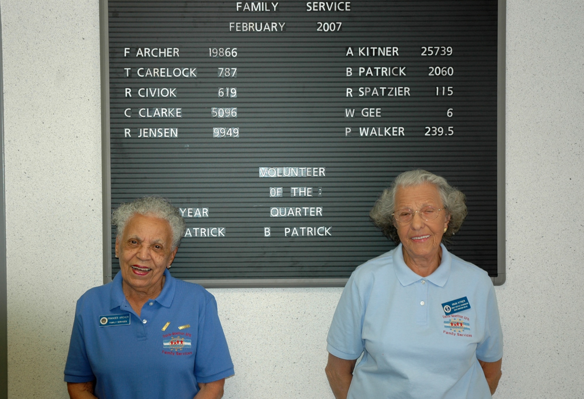 Frances Archer (left) and Anna Kitner, both family services volunteers at D-M's Airman and Family Readiness Center, stand in front of the volunteer service board. As their names at the top of the board indicate, Ms. Archer has volunteered nearly 20,000 hours, and Ms. Kitner has volunteered more than 25,000 hours to Airmen and their families. (U.S. Air Force photo/Staff Sgt. Jake Richmond)