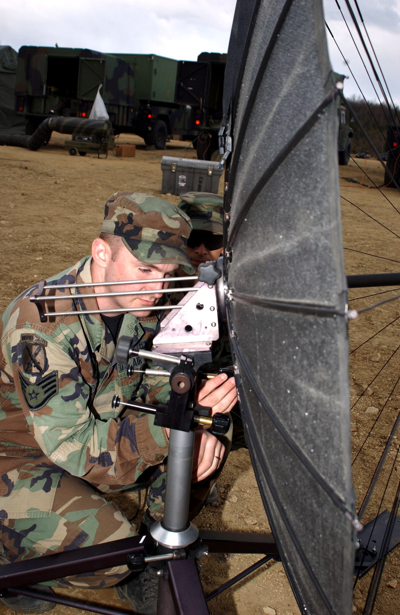 Staff Sgt. Glenn Harrison and Senior Airman Scott Tyler (partially hidden) set up a Tactical Very Small Aperture Terminal dish May 15 to receive weather model images via satellite to predict future weather conditions in the field. The two 3rd Air Support Operations Squadron Airmen are participating in Operation Ursa Minor, a three-day field training exercise at Eielson Air Force Base, Alaska, designed to provide hands-on combat training and experience to Airmen before they deploy to a combat area. (U.S. Air Force photo/Airman 1st Class Jonathan Snyder)