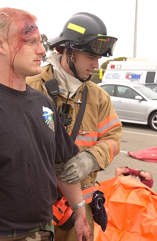 On the first day of the Foggy Shores exercise, Vandenberg Fire Fighter Airman 1st Class Jeremy Di Iullo gives medical attention to Senior Airman Micheal Maskowski who simulates an injury during the earthquake scenario May 14. Both members of the 30th Civil Engineer Squadron participated in this two-day exercise that tests first responders at Vandenberg Air Force Base on how they perform their jobs in a stressful situation. (U.S. Air Force photo by Airman 1st Class Ashley Reed)