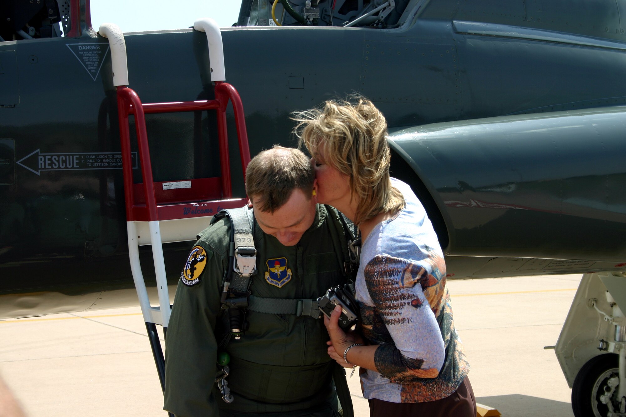 Wichita Falls city manager Darren Leiker receives a kiss from his wife Beth after safely returning from an orientation flight sponsored by the 90th Flying Training Squadron. (U.S. Air Force photo/Staff Sgt. Tonnette Thompson)