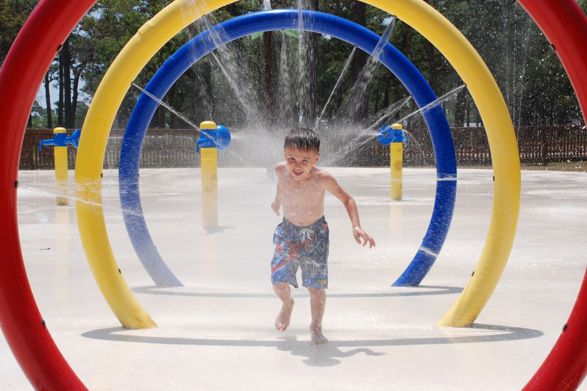 EGLIN AIR FORCE BASE, Fla. -- Brady Towne, 5, runs through the squirting rings at the Splash Park across from Oakhill Elementary School May 17. The Splash Park is open from 8 a.m. to 8 p.m. seven-days a week. It is closed the first Wednesday of each month. It also closes in the event of inclement weather. (U.S. Air Force photo by Staff Sgt. Mike Meares)   