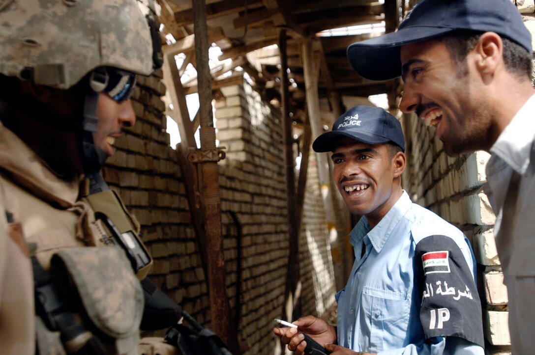 Staff Sgt. Michael Ellis laughs with Iraqi police, May 9, 2007, in a Baghdad police station. Ellis is with Detachment 3, 732nd Expeditionary Security Forces Squadron, whose members mentor, coach and teach Iraqi police as part of their police transition team duties. 