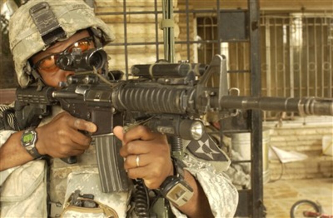 U.S. Army Spc. A.J. Jackson looks for snipers in the area during a cordon and search in Ameriyah, Iraq, on May 16, 2007.  Jackson is assigned to Alpha Company, 1st Battalion, 23rd Infantry Regiment, 3rd Stryker Brigade Combat Team, 2nd Infantry Division.  