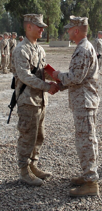 LtCol. James F McGrath, the battalion commander for 3rd battalion, 6th Marine Regiment, shakes the hand of Lance Cpl. Blake A Soileau, 19, from Zachary, La., after awarding him the Navy and Marine Corps Commendation Medal, with combat distinguishing device. Soileau, a member of K Company, received the award for exposing himself to enemy machine gun fire while stopping a explosive-laden dump truck from entering the platoon’s forward operating base. His accurate fire brought the truck to a halt saving the lives of his fellow Marines. (Photo by 1stLt. Jeremy M. Nelson)