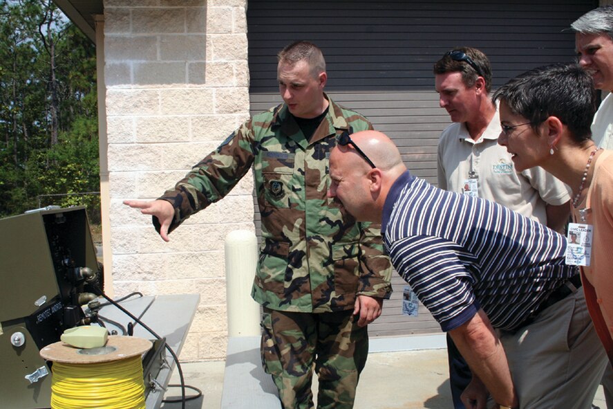 Staf Sgt. Daniel Robinson, 1st Special Operations Civil Engineer Squadron Explosive Ordinance Disposal, explains to the 1st Special Operations Wing honorary commanders how the EOD robot is used in conjunction with a monitor, so the EOD Airmen can view the potential danger from a distance. The 1st SOW honorary commanders are Allen Newton, Carla Reinlie, Shane Moody and Scott Gashaw. (U.S. Air Force photo by Amy Oliver)