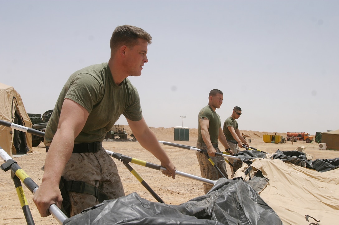 (Left to right) Sgt. Brandon A. VanSickle, Cpl. Phillip Quinones and Cpl. Miguel A. Mendoza, all from the 26th Marine Expeditionary Unit's Headquarters Commandant Section, break out a tent at a MEU camp in the Middle East May 22, 2007.  The section is responsible for attending to virtually every day to day need of MEU living spaces ashore and at sea.  (Offical USMC photo by Cpl. Jeremy Ross) (Released)