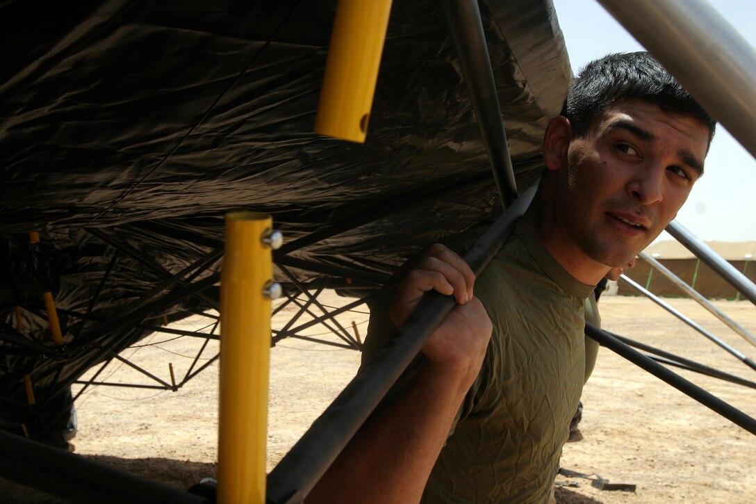 Lance Cpl. Alexander Garcia, from the 26th Marine Expeditionary Unit's Command Element, helps the unit's Headquarters Commandant Section erect a tent at a MEU camp in the Middle East May 22, 2007.  The section is responsible for attending to virtually every day to day need of MEU living spaces ashore and at sea.  (Offical USMC photo by Cpl. Jeremy Ross) (Released)