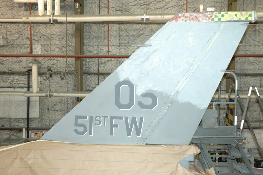 OSAN AIR BASE, Republic of Korea --  Work progresses on removing the old tailflash from Brig. Gen. Joe Reynes' F-16 Fighting Falcon. The jet's tail was repainted with a Korean Conflict-era "Checkertail" design. (U.S. Air Force photo by Tech. Sgt. Michael O'Connor)