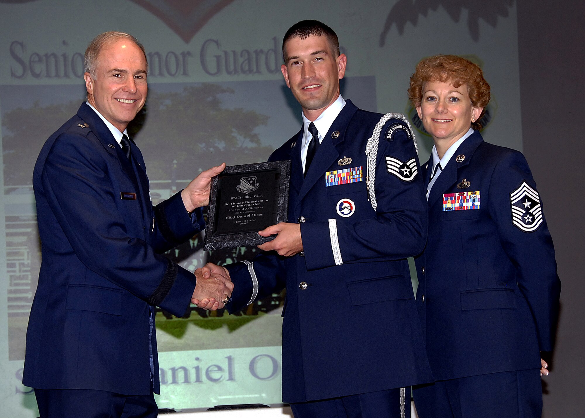 Staff Sgt. Daniel Olsen, center, of the 362nd Training Squadron accepts his award as Senior Honor Guardsman of the Quarterly during the 82nd Training Wing Quarterly Awards luncheon May 16 at the Sheppard Club. Also pictured are 82nd TRW Commander Brig. Gen. Richard Devereaux and Chief Master Sgt. Jeannie McLean, the wing's command chief master sergeant. (U.S. Air Force photo/Harry Tonemah)