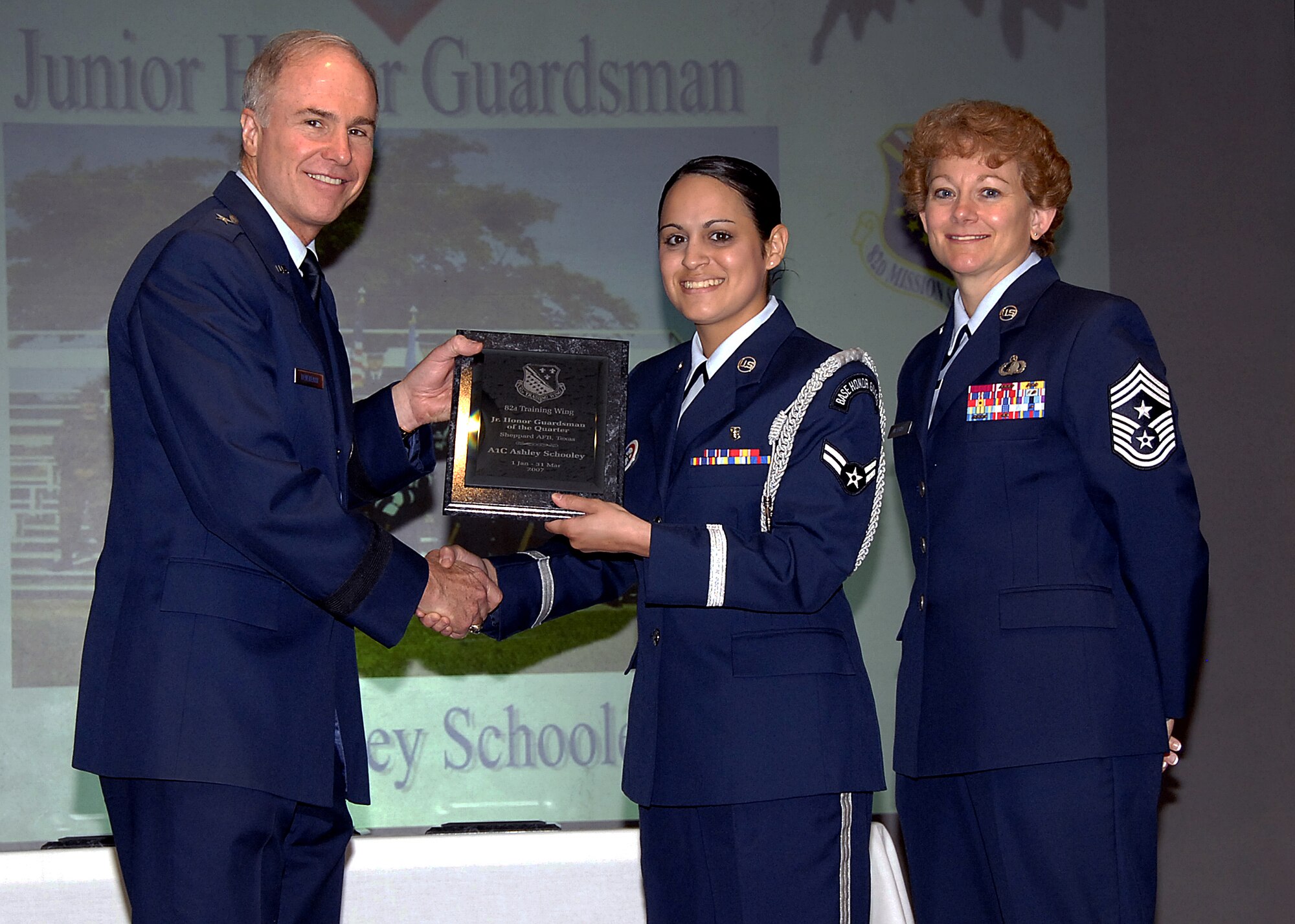 Brig. Gen. Richard Devereaux, left, 82nd Training Wing commander, presents Airman 1st Class Ashley Schooley of the 82nd Medical Operations Squadron the Junior Honor Guardsman of the Quarter award May 16 at the wing's quarterly award luncheon at the Sheppard Club. Also pictured is Chief Master Sgt. Jeannie McLean, command chief master sergeant for the 82nd TRW. (U.S. Air Force photo/Harry Tonemah)