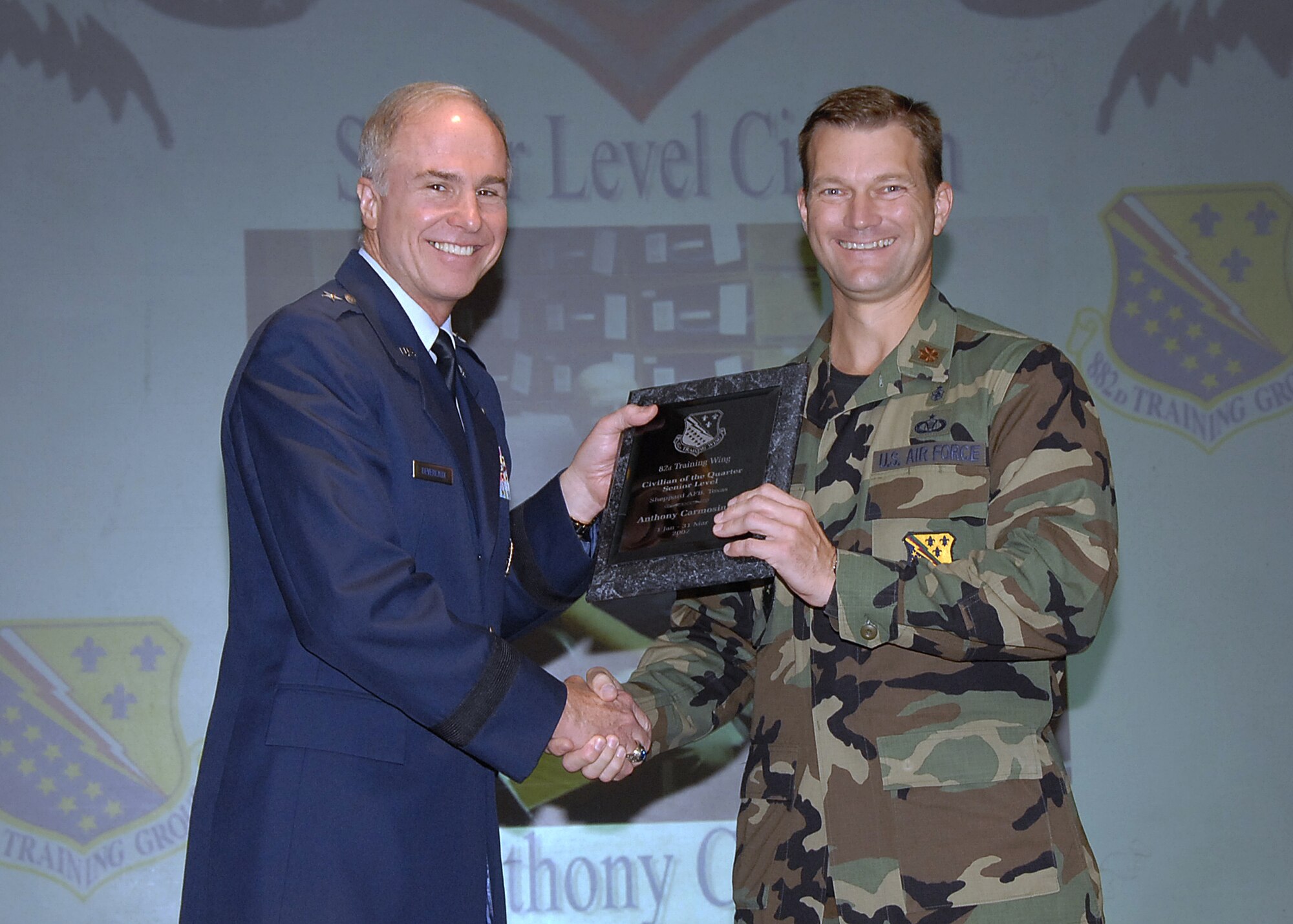 Maj. Paul Bailey, right, accepts the Senior-level Civilian of the Quarter award on behalf of Anthony Carmosino of the 882nd Training Support Squadron May 16 at the 82nd Training Wing Quarterly Awards luncheon.  Mr. Carmosino implemented processes that led to the squadron's recognition by Air Education and Training Command award for Small Group Productivity Excellence. In his off time, he volunteered time to deliver meals as part of the Burkburnett Meals on Wheels program. Also pictured with Major Bailey is 82nd Training Wing Commander Brig. Gen. Richard Devereaux. (U.S. Air Force photo/Harry Tonemah)