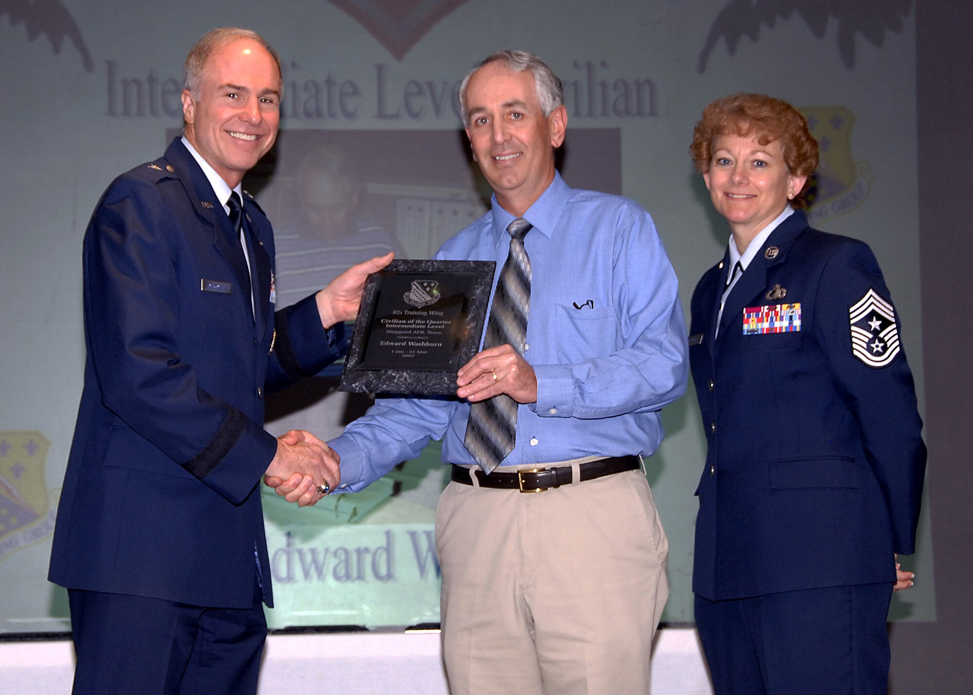 Edward Washburn, center, of the 882nd Training Support Squadron was named the Intermediate-level Civilian of the Quarterly during a luncheon May 16 at the Sheppard Club. Mr. Washburn distinguished himself as a people manager by briefing leadership on assignment code changes as well as correcting manning balances in the 882nd Training Group. He is also active in his church as well as leading in professional development in the group. Also pictured are, left, 82nd Training Wing Commander Brig. Gen. Richard Devereax and Chief Master Sgt. Jeannie McLean, the 82nd TRW command chief master sergeant. (U.S. Air Force photo/Harry Tonemah)