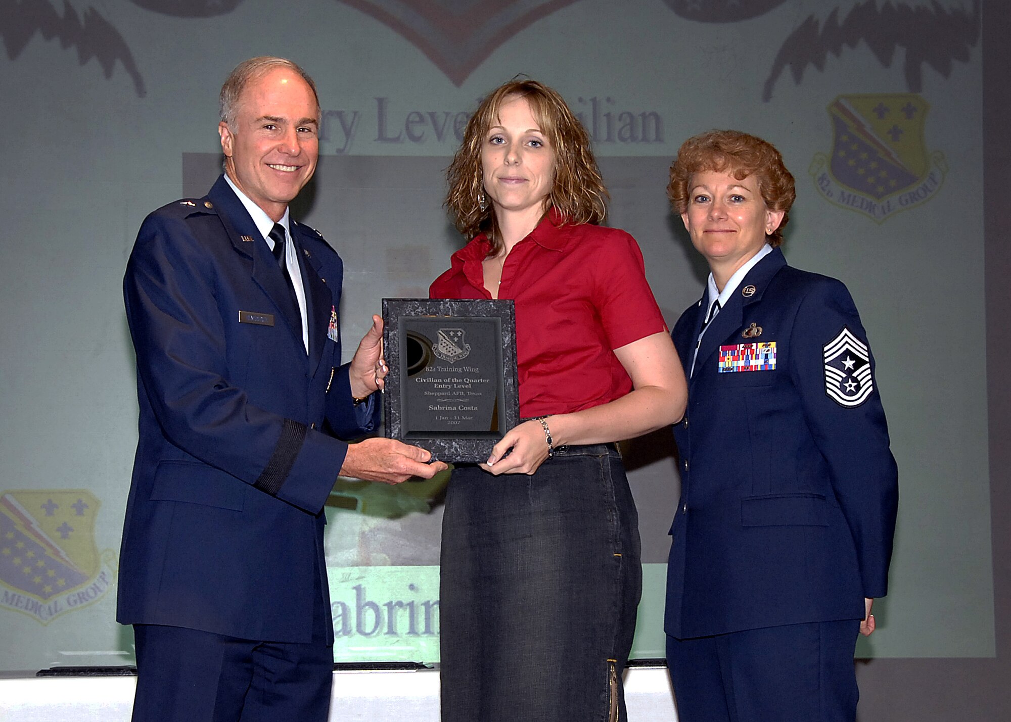Sabrina Costa, center, of the 82nd Dental Squadron accepts the Entry-level Civilian of the Quarter award May 16 for the 82nd Training Wing during a luncheon. Ms. Costa provided support to her squadron by ensuring dental records for deployers were accurate, leading to a 98 percent readiness rate. She alos support local Relay for Life efforts and volunteered time for child advocacy programs. Also pictured are, left, 82nd Training Wing Commander Brig. Gen. Richard Devereaux and, right, Chief Master Sgt. Jeannie McLean, the 82nd TRW command chief master sergeant. (U.S. Air Force photo/Harry Tonemah)