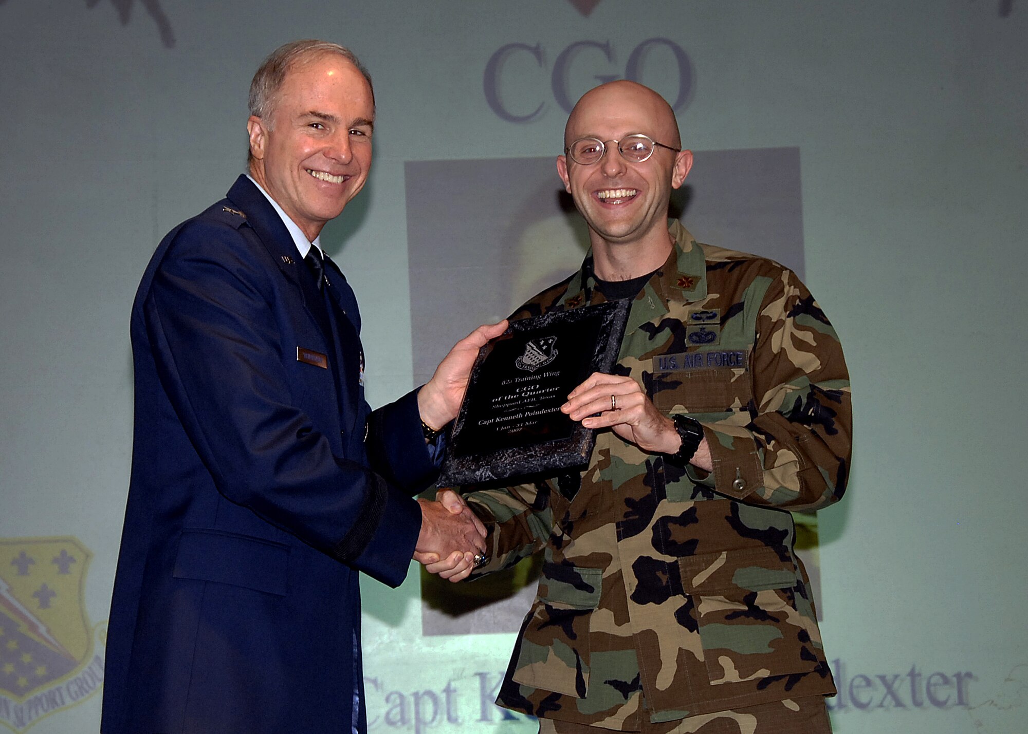 Capt. Kenneth Poindexter (not pictured) was named the CGO of the Quarter May 16 during the 82nd Training Wing Quarterly Awards luncheon at the Sheppard Club. Captain Poindexter singled himself out by bringing in a new criminal and terrorist watchlist at the gates, resulting in 13 arrests in 40 days. He also initiated a neighborhood watch program in Capehart Housing with the Wichita Falls Police Department and supervised the John Tower Elementary D.A.R.E. program. Maj. Gregory Nowak, 82nd Security Forces Squadron commander, accepted the award on Captain Poindexter's behalf. Also pictured is Brig. Gen. Richard Devereaux, 82nd TRW commander. (U.S. Air Force photo/Harry Tonemah)