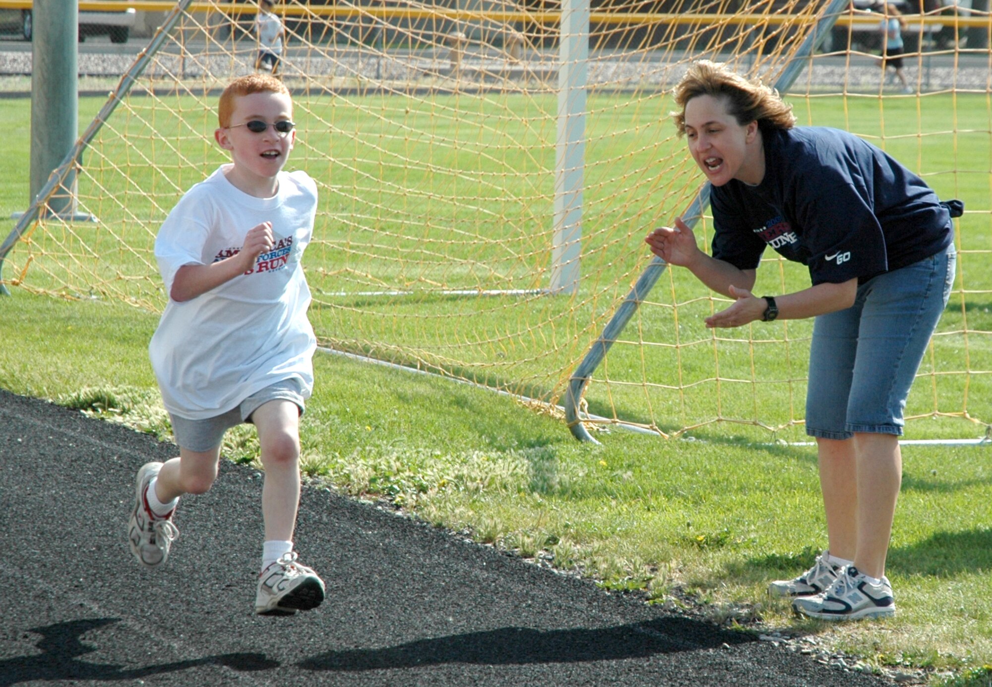 MOUNTAIN HOME AIR FORCE BASE, Idaho -- Lissa Hall, the Boys and Girls Club coordinator for the youth center here, cheers Andrew on as he runs a mile during the America’s Armed Forces Kids Run here May 19. Held in conjunction with Armed Forces Day, the run is geared for children ages five and up to promote a more active lifestyle. U.S. Air Force photo/Airman Samantha S. DeVries