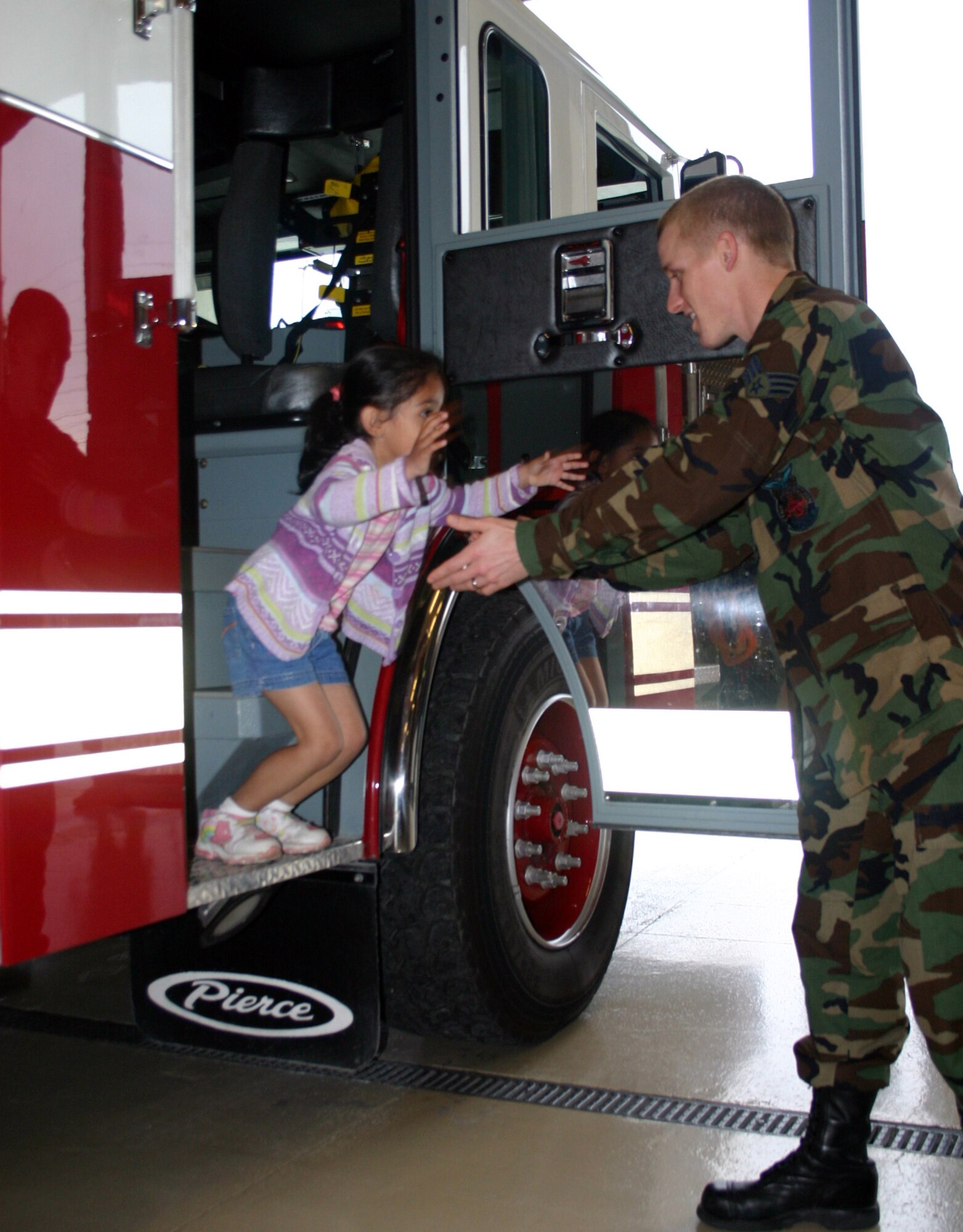 LAUGHLIN AIR FORCE BASE, Texas --Senior Airman Adam Hall, 47th Flying Training Wing fire department, lends a hand to a girl from a kindergarten class in Rocksprings, Texas, to get down from a fire truck. Firefighters helped take several groups of students through Laughlin's fire station, demonstrating to children of all ages how they use firefighting equipment.  (U.S. Air Force photo by Airman Sara Csurilla)