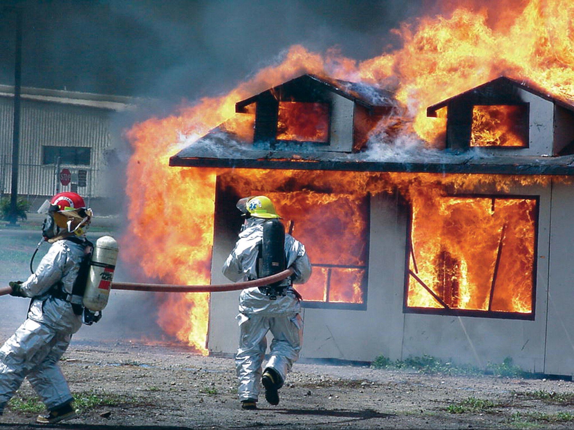 Firefighters from the 15th Civil Engineer Squadron Fire Protection Flight train on a deserted dwelling at Hickam Air Force Base, Hawaii. Safety officials remind people it doesn't take much to turn this training scenario into reality when people don't pay attention cooking or barbecuing. (Courtesy photo)
