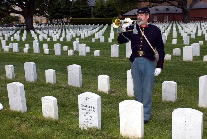 Kevin Ritton, a Civil War reenactment performer with the 79th New York Volunteer Infantry, plays "Taps" May 19 behind the headstone of Pvt. Charles Veale, a Civil War soldier with Company D, 4th U.S. Colored Troops who received the Medal of Honor for his acts of heroism at Cahpins Farm, Va., Sept. 29, 1864. Earlier, Mr. Ritton and seven other musicians played "Taps" as part of "Echo Taps Worldwide," which featured buglers and trumpeters performing simultaneously at veterans' cemeteries worldwide in observance of Armed Forces Day. (U.S. Air Force photo/Staff Sgt. Bryan D. Axtell)