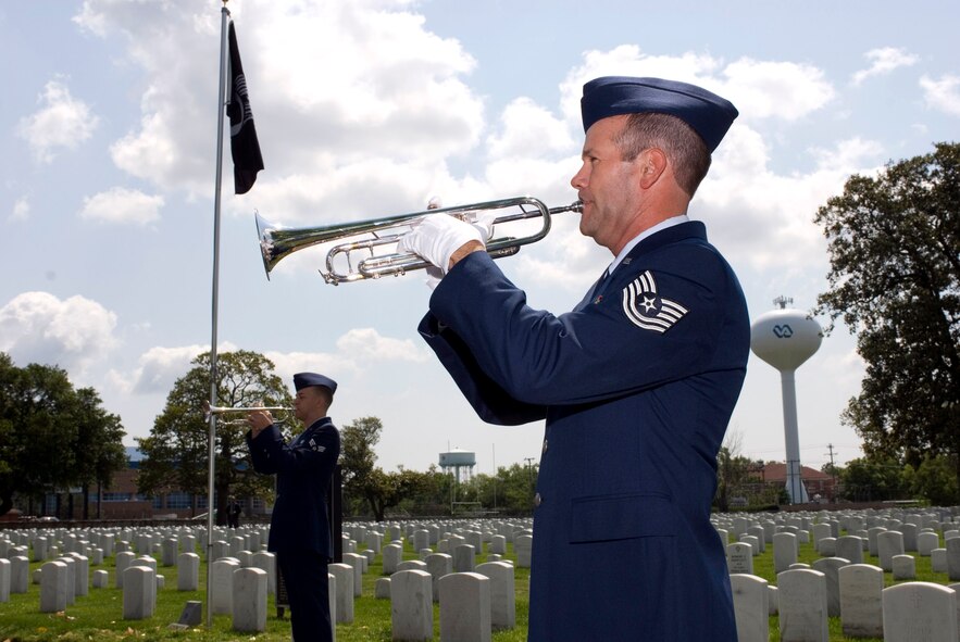 Retired Tech. Sgt. Robert E. Havener (right) and Senior Airman Justin D. Hunniecutt play "Taps" along with seven other musicians at the Hampton-Richmond National Cemetery Complex May 19 as part of "Echo Taps Worldwide." The event featured buglers and trumpeters performing simultaneously at veterans cemeteries worldwide in observance of Armed Forces Day. (U.S. Air Force photo/Staff Sgt. Bryan D. Axtell) 