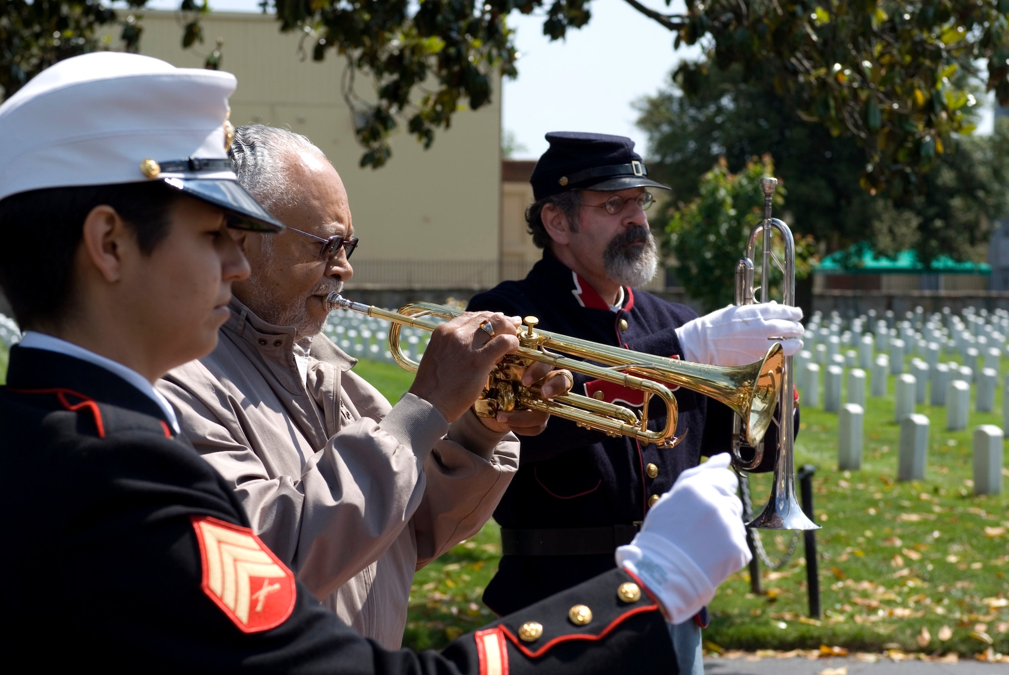 Retired Air Force Senior Master Sgt. Bob Ransom Jr. (center) and Kevin Ritton, a Civil War reenactment performer with the 79th  New York Volunteer Infantry, play "Taps" as Marine Corps Sgt. Stephanie Garza conducts. Eight musicians played "Taps" at the Hampton-Richmond National Cemetery Complex May 19 as part of "Echo Taps Worldwide," which encouraged buglers and trumpeters to perform simultaneously at veterans cemeteries worldwide in observance of Armed Forces Day. (U.S. Air Force photo/Staff Sgt. Bryan D. Axtell) 