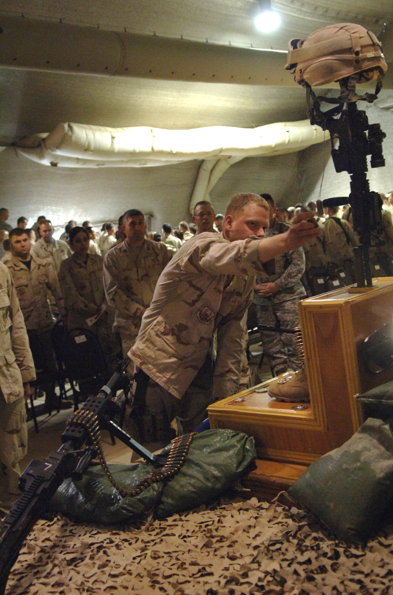 Senior Airman Daniel Hunsperger says goodbye to his supervisor, Staff Sgt. John T. Self, during a May 18 memorial ceremony in the town hall at Balad Air Base, Iraq. Sergeant Self died during combat operations May 14 in the Baghdad area. Airman Hunsperger is with Det. 3, 332nd Expeditionary Security Forces Squadron. (U.S. Air Force photo/Tech. Sgt. Alan Port) 
