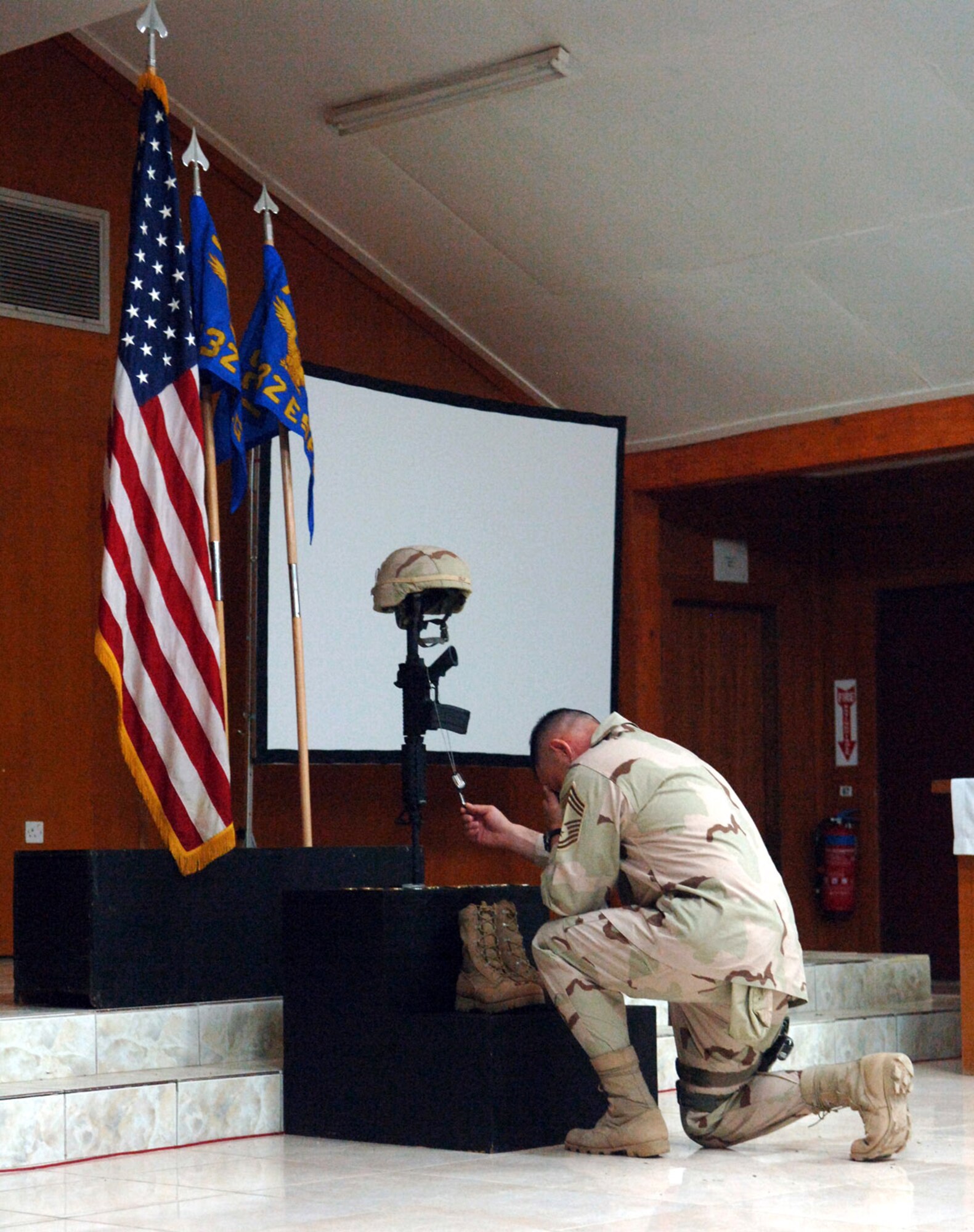 Chief Master Sgt. Carlos Smittle holds Staff Sgt. John T. Self's dog tags to show respect during Sergeant Self's memorial ceremony May 18 at Balad Air Base, Iraq. Sergeant Self died during combat operations May 14 in the Baghdad area. Chief Smittle is with the 447th Expeditionary Security Forces Squadron. (U.S. Air Force photo/Airman 1st Class Jonathan Steffen)
