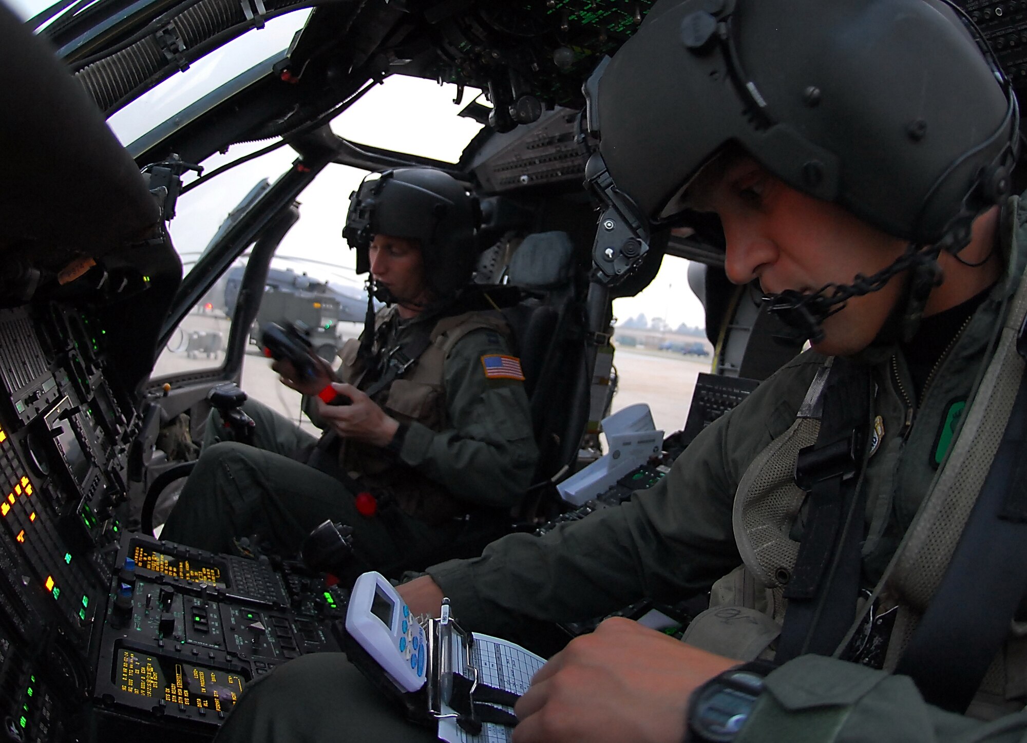 MOODY AIR FORCE BASE, Ga, --   1st Lt. Mike Kingry, an HH-60G Pave Hawk co-pilot assigned to Moody's 41st Rescue Squadron, programs his navigational instruments, as Capt. Jason Rodgers, the HH-60G’s aircraft commander, prepares his night vision goggles before a night training mission May 15. The 41st RQS "Jolly Green Giants" routinely fly night missions to maintain proficiency in their primary mission - combat search and rescue.  (U.S. Air Force photo by Tech. Sgt. Parker Gyokeres) 