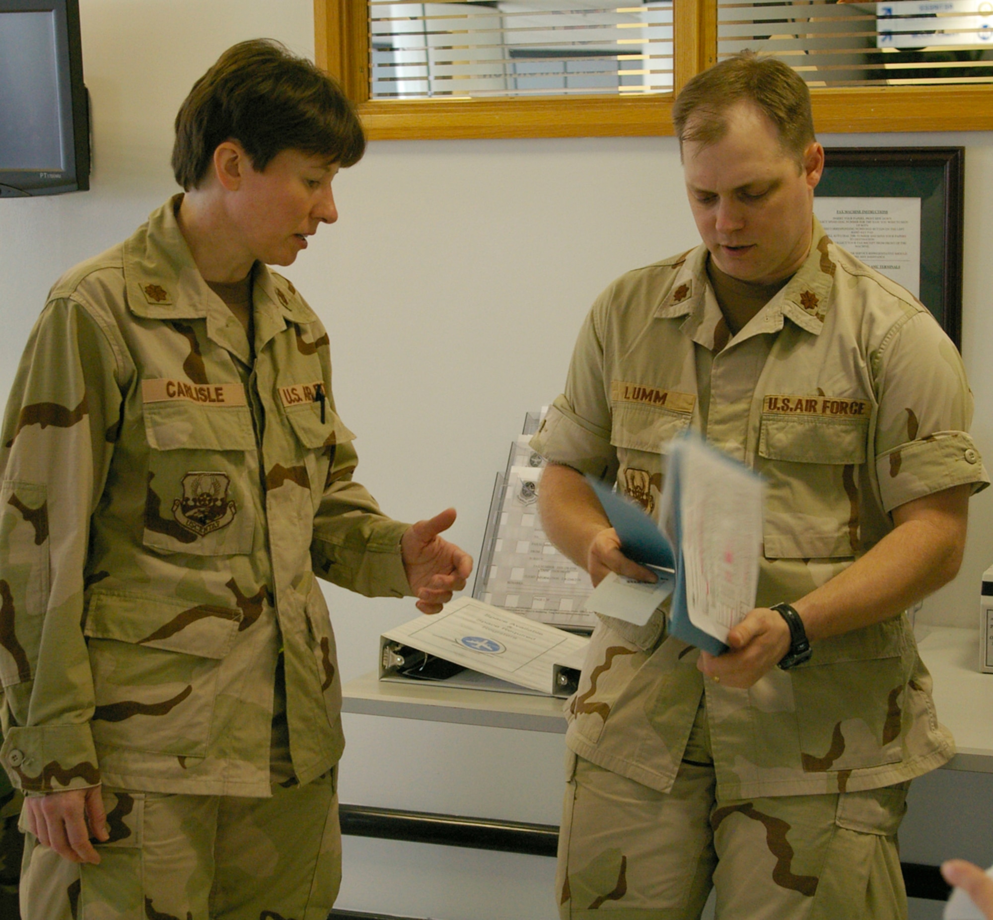 Maj. Mary Carlisle, left, a nurse in the 48th Medical Operations Squadron, RAF Lakenheath, talks with troop commander Maj. Jeff Lumm, 100th Logistics Readiness Squadron, May 18 at the 727th Air Mobility Command passenger terminal at RAF Mildenhall. The officers were among 65 troops preparing to deploy to southwest Asia. (U.S. Air Force photo by Karen Abeyasekere)