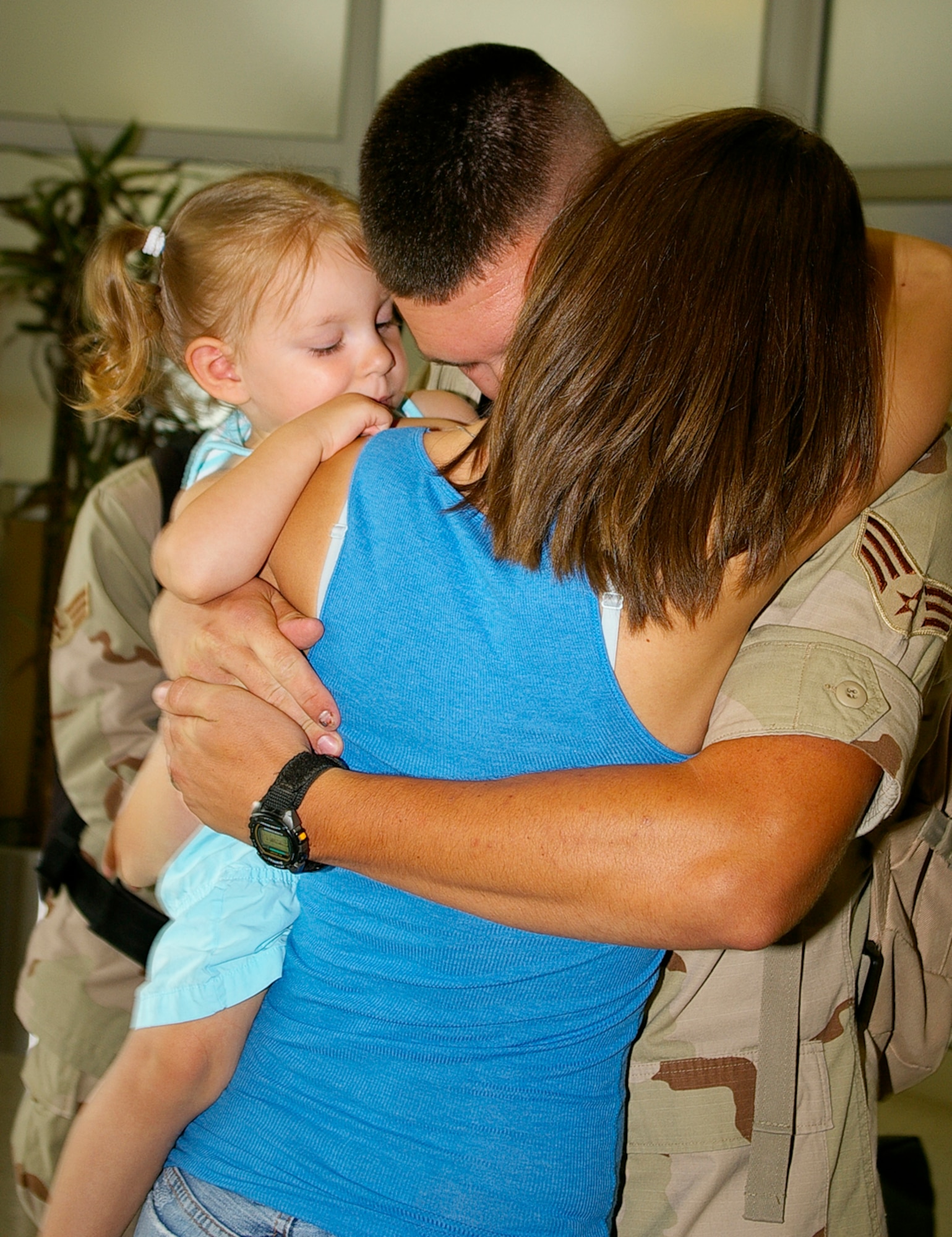 Senior Airman John Long, 100th Maintenance Squadron, hugs his wife, Danielle, and daughter, Cami, 2, as he returns from a four-month deployment in southwest Asia May 19. (U.S. Air Force photo by Karen Abeyasekere)