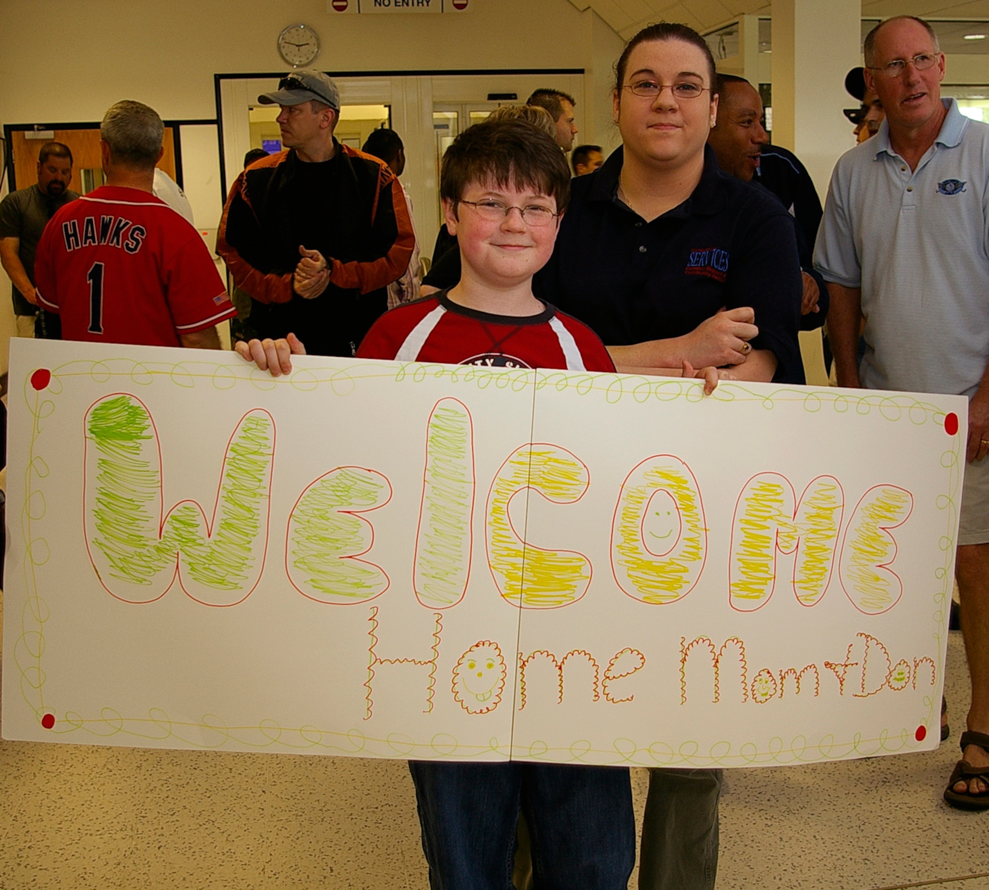 Doug Ream, 13, and his sister, Stacey, both RAF Mildenhall family members, await the arrival of their mom, Senior Master Sgt. Cynthia Ream, 100th Aircraft Maintenance Squadron, as she and other members from RAF Mildenhall arrive back from deployment May 19. (U.S. Air Force photo by Karen Abeyasekere)