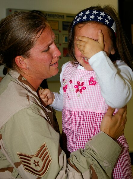 Tech. Sgt. Hope Hendershot, 100th Services Squadron, shares an emotional moment with daughter, Emily, 5, as she returns May 19 from a deployment to southwest Asia. Sergeant Hendershot was one of 93 troops returning to RAF Mildenhall after their four-month deployment. (U.S. Air Force photo by Karen Abeyasekere)