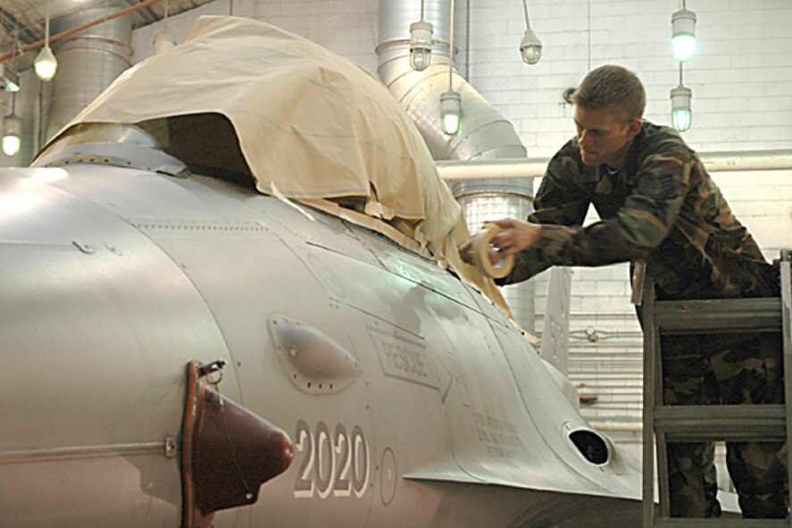 OSAN AIR BASE, Republic of Korea -- Staff Sgt. Jonathan Randolph, 51st Maintenance Squadron's corrosion element, prepares Brig. Gen. Joe Reynes' F-16 Fighting Falcon for its new paint job recently. The corrosion element is painting five command jets here with a Korean Conflict-era "Checkertail" design. (U.S. Air Force photo by Tech. Sgt. Michael O'Connor)