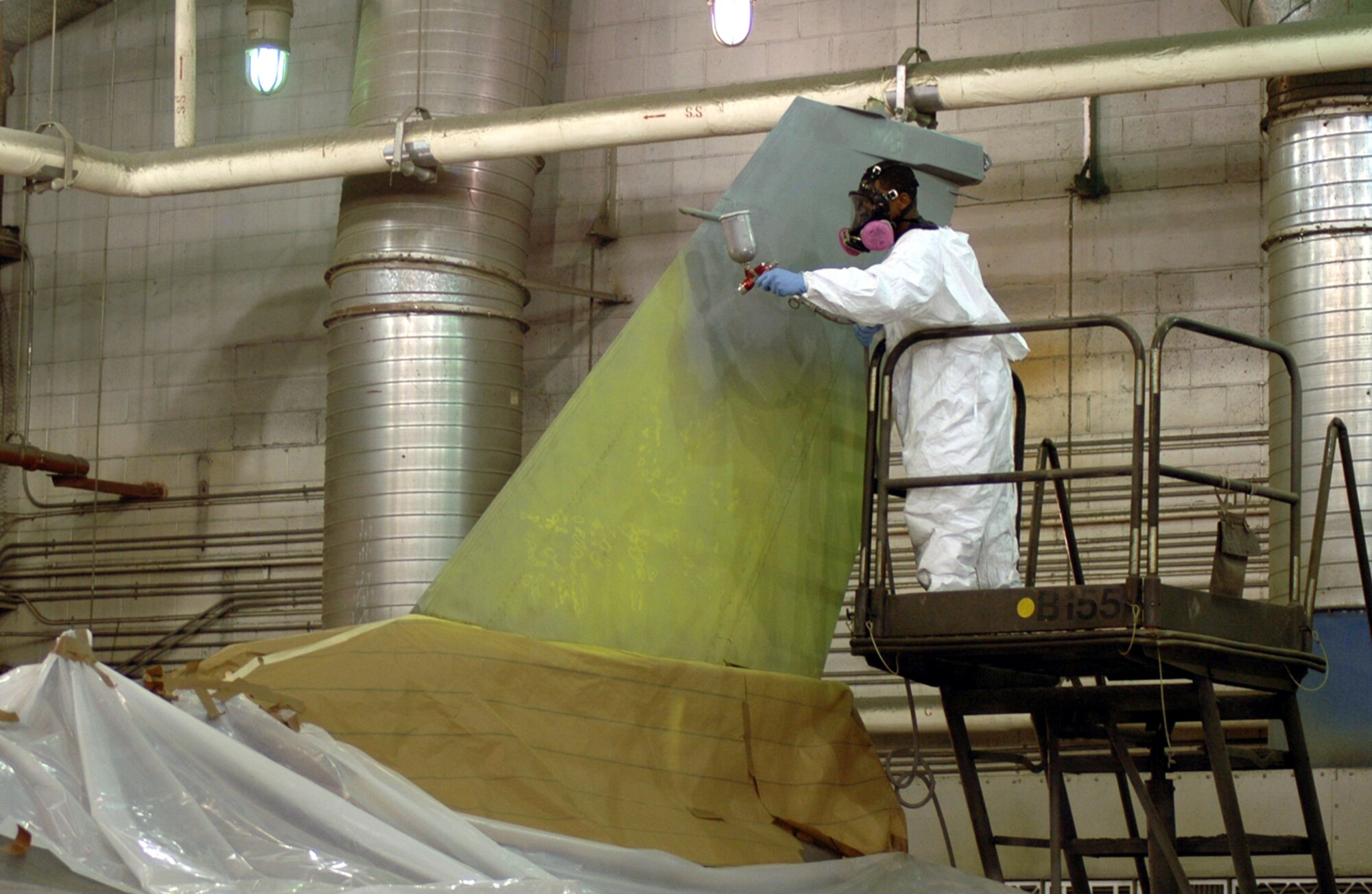 OSAN AIR BASE, Republic of Korea --  An airman from the 51st Maintenance Squadron's corrosion element sprays new paint onto the tail of Brig. Gen. Joe Reynes' F-16 Fighting Falcon. The heritage "Checkertail" design is a way to connect the 51st Fighter Wing to its past, said Brig. Gen. Reynes. (U.S. Air Force photo by Tech. Sgt. Michael O'Connor)