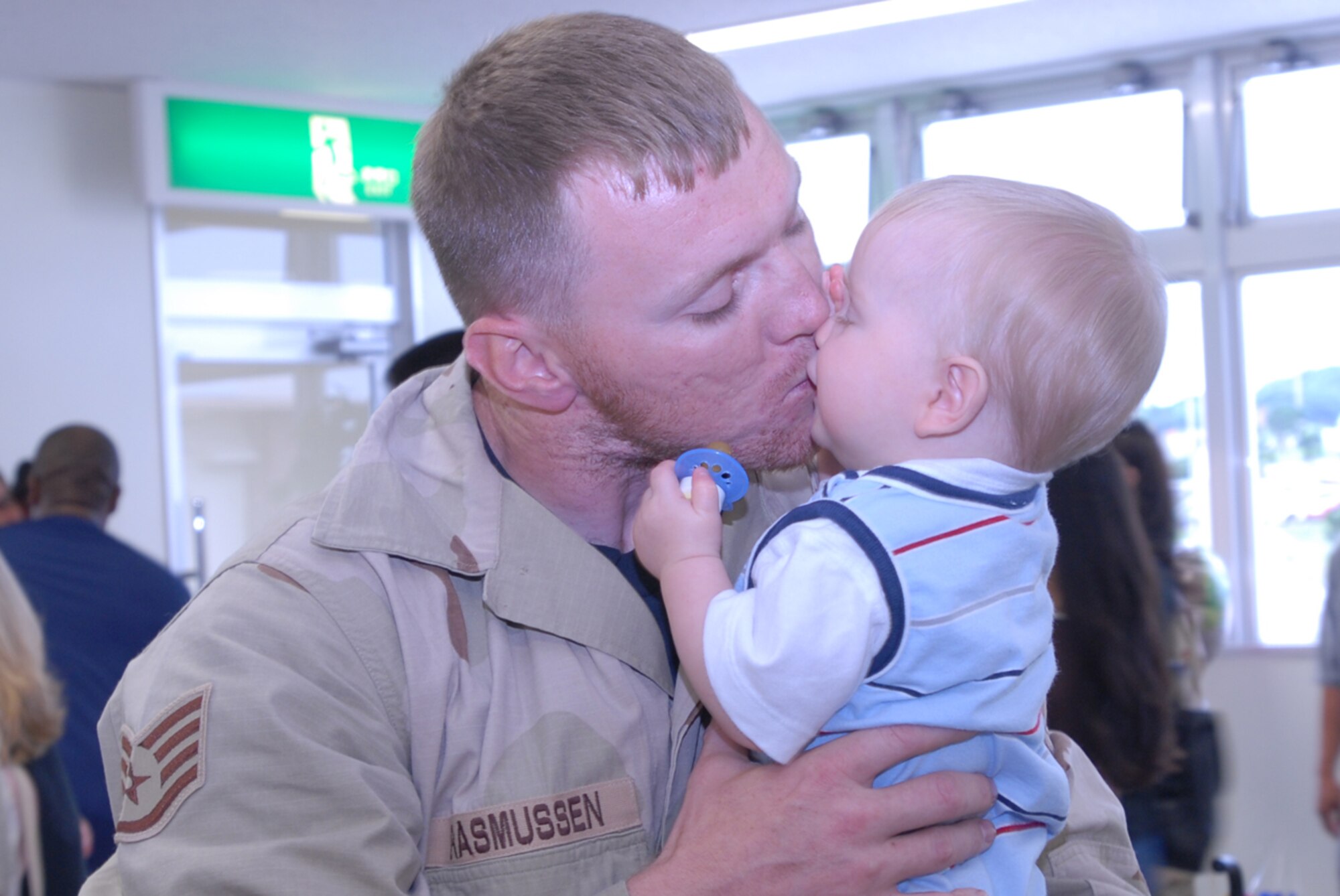 Staff Sgt. A.J. Rasmussen, 18th Civil Engineer Squadron, kisses his 10 month-old son, Calvin, May 19 upon his return to Kadena Air Base, Japan, following a four-month deployment to Balad Air Base, Iraq. More than 120 Team Kadena members returned from deployment that day.
(U.S. Air Force/Master Sgt. Jeff Loftin)