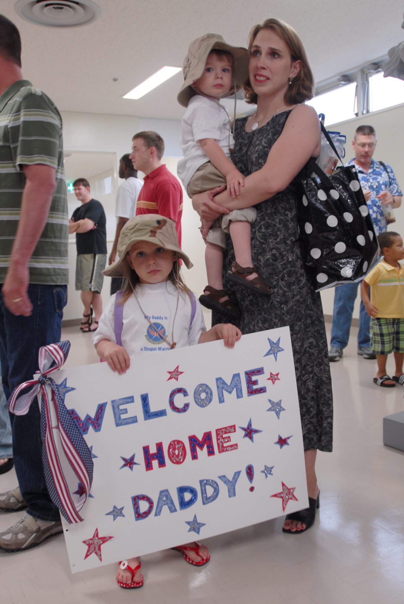 Laura Rice, with her two children Emily and Jonathan, wait for the arrival of her husband Maj. Jon Rice, 18th Operations Support Squadron, from his four-month deployment to Balad Air Base, Iraq, May 19. More than 120 members returned to Kadena Air Base, Japan, from deployment that day.
(U.S. Air Force/Master Sgt. Jeff Loftin)
